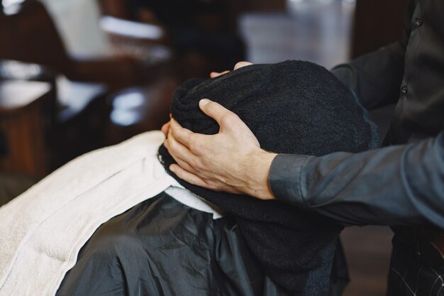 Mann mit Bart. Friseur mit einem Kunden. Mann mit Kamm und Schere