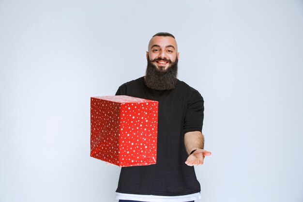 Mann mit Bart mit roter Geschenkbox
