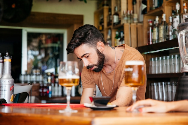 Mann mit Bier an bar
