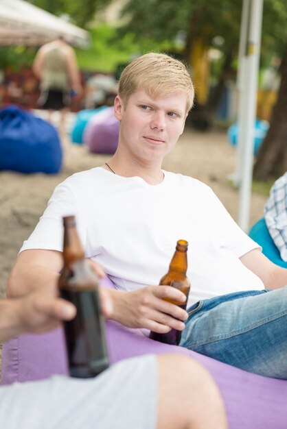 Mann mit Bier, das unter Freunden sich entspannt