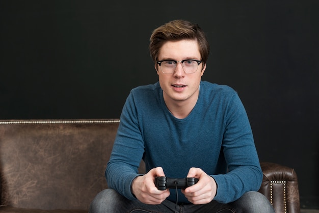 Kostenloses Foto mann mit brille spielt mit einem controller