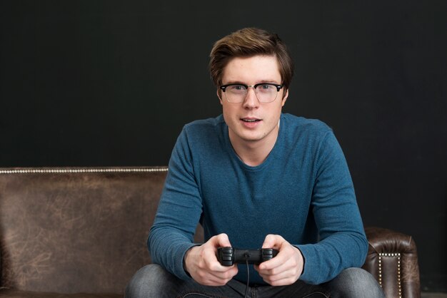 Mann mit Brille spielt mit einem Controller