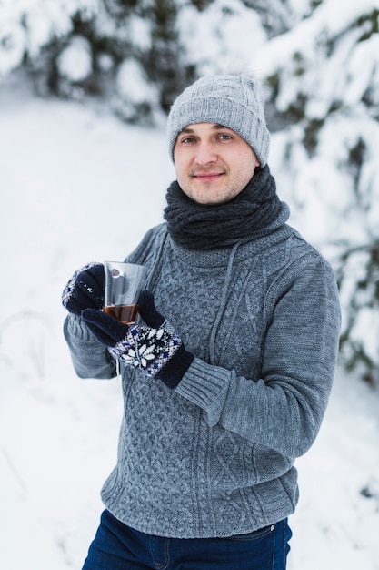 Mann mit dem Tee, der Kamera betrachtet