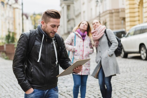 Mann mit der Tablette, die auf Straße steht