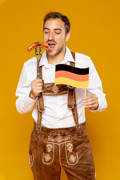 Kostenloses Foto mann mit deutscher wurst und flagge