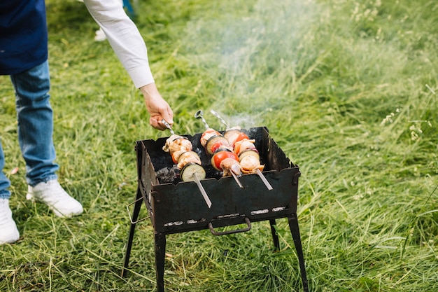 Kostenloses Foto mann mit einem grill in der natur