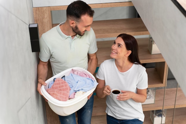 Mann mit einem Haufen schmutziger Kleidung im Korb