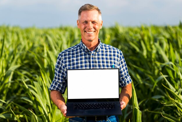 Mann mit einem Laptop in einem Getreidefeldmodell