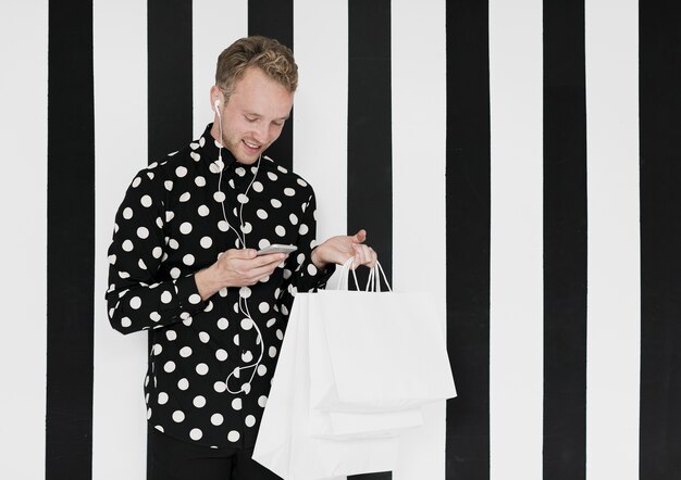 Mann mit Einkaufstüten auf einem gestreiften Hintergrund