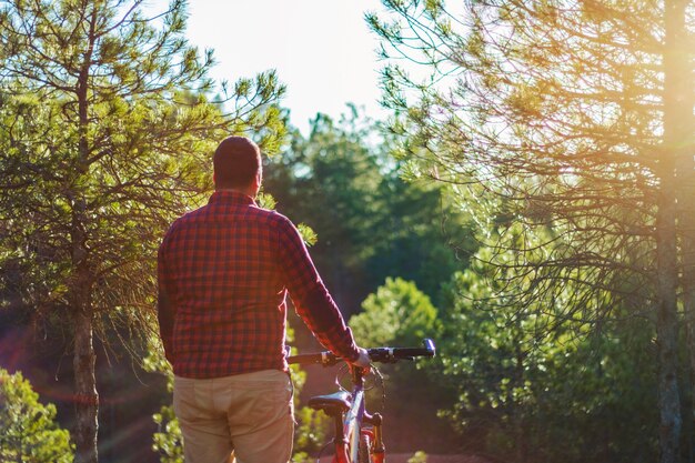 Mann mit Fahrrad Blick auf Wald