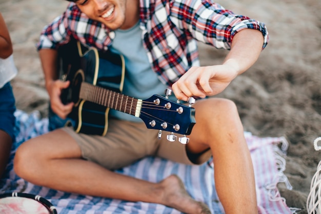 Mann mit Gitarre am Strand