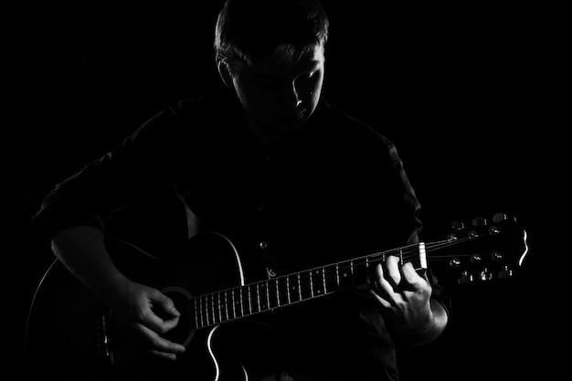Mann mit Gitarre in der Dunkelheit