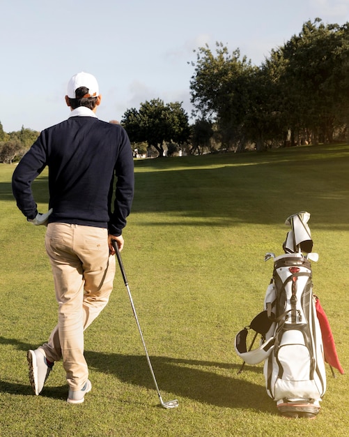 Mann mit Golfschlägern auf dem Feld