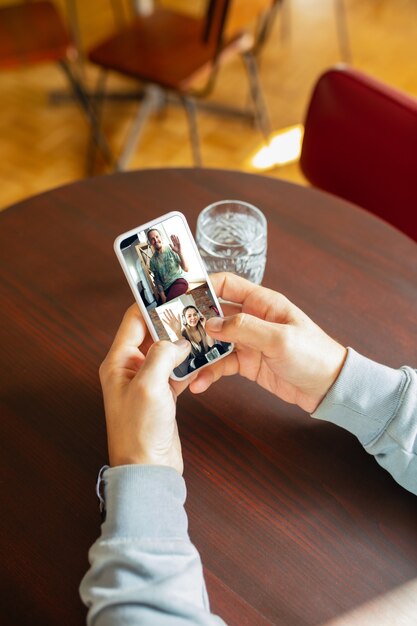 Mann mit Handy für Videoanruf beim Trinken von Wasser