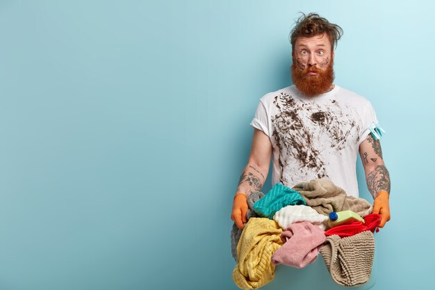 Mann mit Ingwerbart, der Wäsche tut