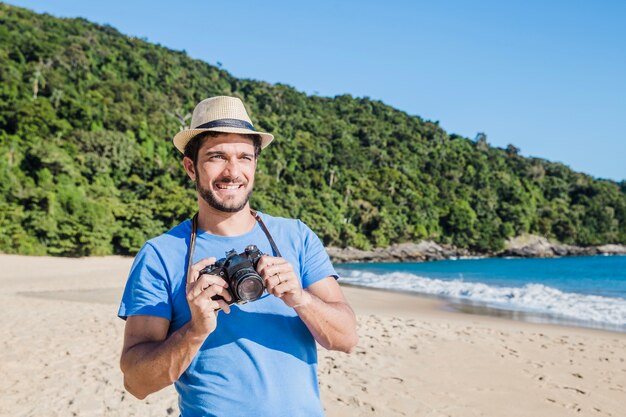 Mann mit Kamera am Strand