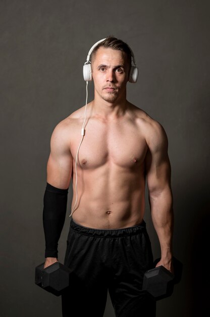Mann mit Kopfhörern und Gewichten