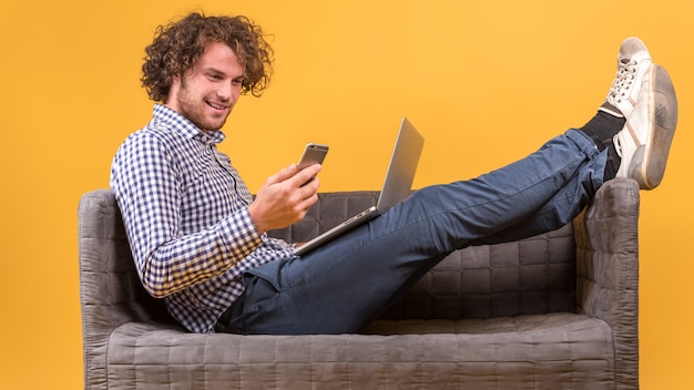 Mann mit Laptop auf der Couch