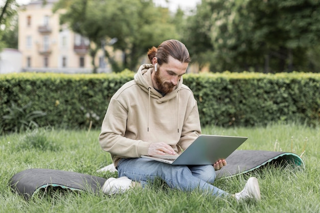 Kostenloses Foto mann mit laptop im stadtpark