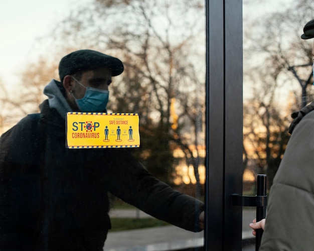 Kostenloses Foto mann mit maskenöffnungstür