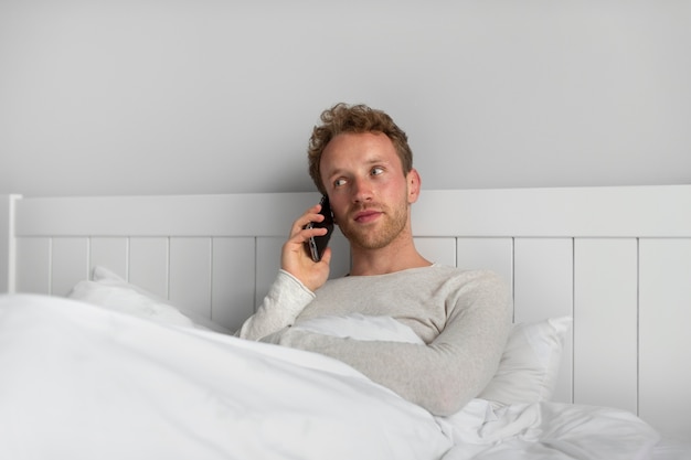 Kostenloses Foto mann mit mittlerem schuss, der am telefon telefoniert