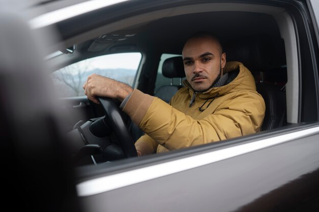 Kostenloses Foto mann mit mittlerem schuss, der auto fährt