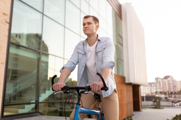 Mann mit mittlerem Schuss, der Fahrrad fährt