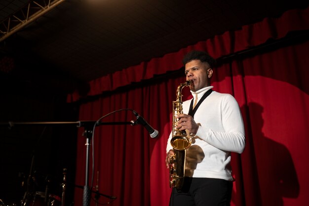 Kostenloses Foto mann mit mittlerem schuss, der saxophon spielt