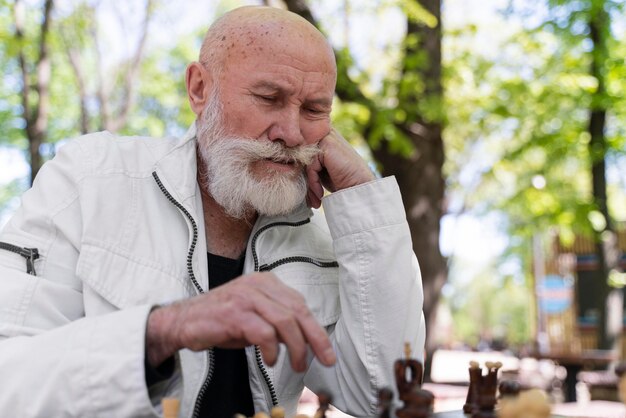 Kostenloses Foto mann mit mittlerem schuss, der schach spielt