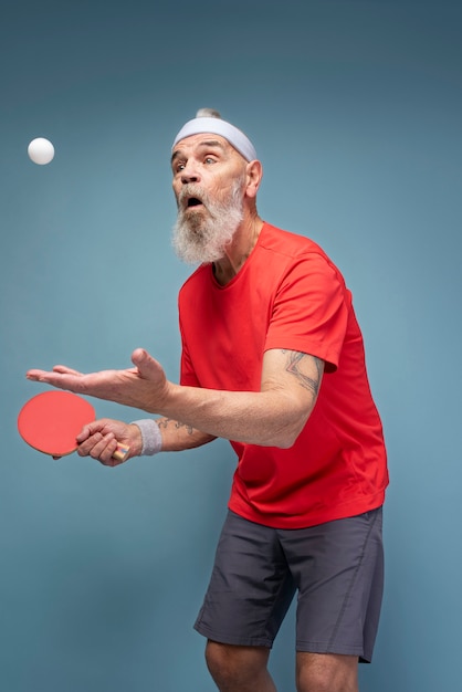 Kostenloses Foto mann mit mittlerem schuss, der tischtennis spielt