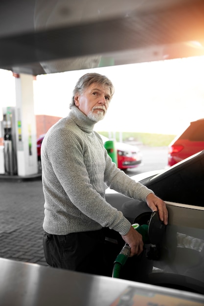 Mann mit mittlerer Schusskraft, der Gas pumpt