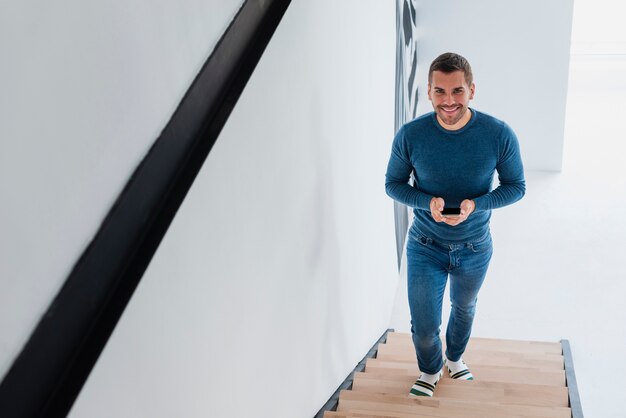 Mann mit Mobile in den Händen, die Treppe klettern