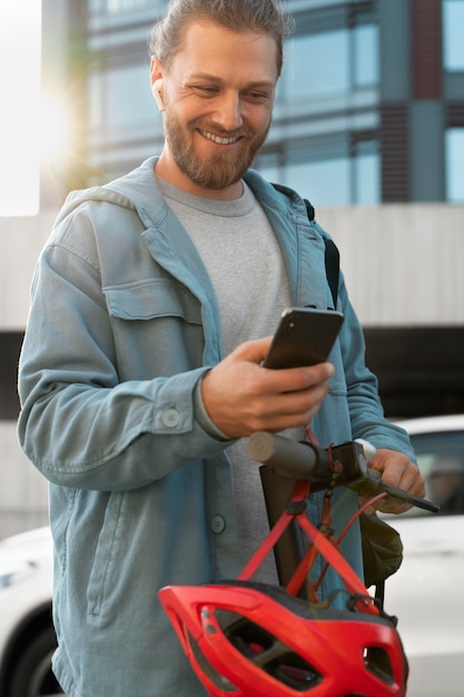 Mann mit Roller schaut auf sein Handy