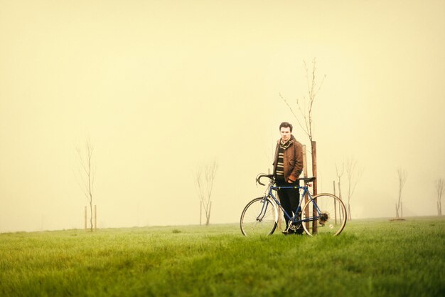 Mann mit seinem Fahrrad an einem nebligen Tag