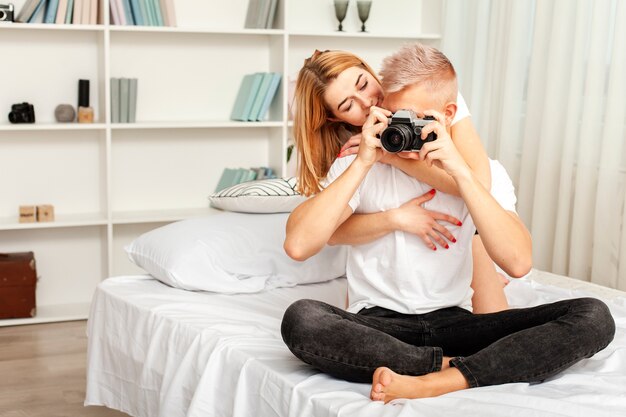 Mann mit seiner Freundin, die ein Foto mit einer Kamera macht