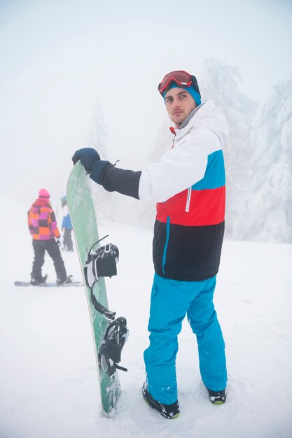 Mann mit Snowboard während der Winterzeit