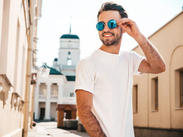 Mann mit Sonnenbrille, die weißes T-Shirt posierend aufwirft