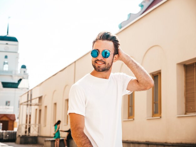 Mann mit Sonnenbrille, die weißes T-Shirt posierend aufwirft