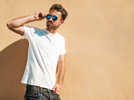 Mann mit sonnenbrille, die weißes t-shirt posierend aufwirft