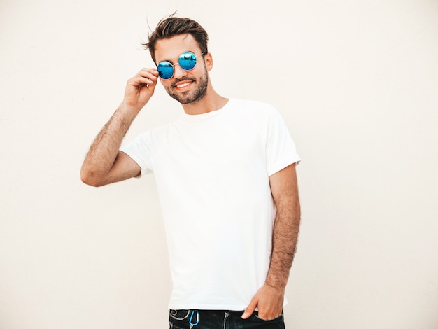 Mann mit Sonnenbrille, die weißes T-Shirt posierend aufwirft