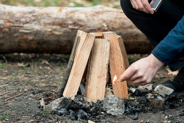 Mann mit Streichholz machen Lagerfeuer