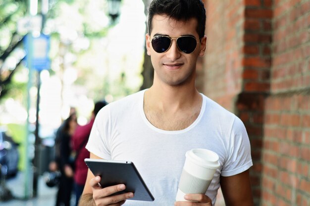 Mann mit tablette und trinkendem kaffee