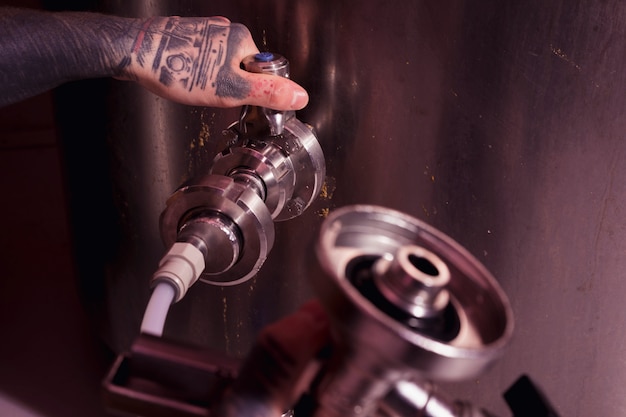 Mann mit Tätowierungen, die Handwerksbier herstellen