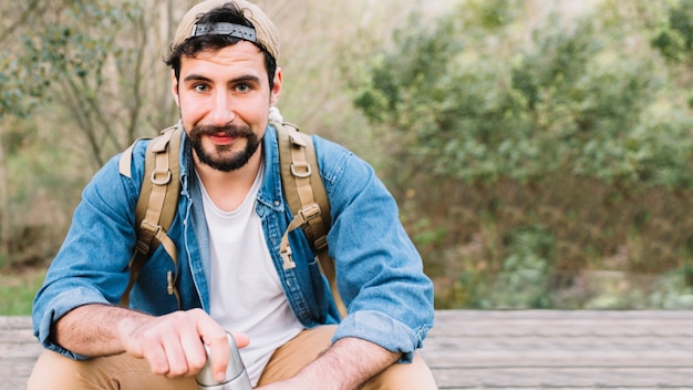 Mann mit Thermosflasche in der Natur