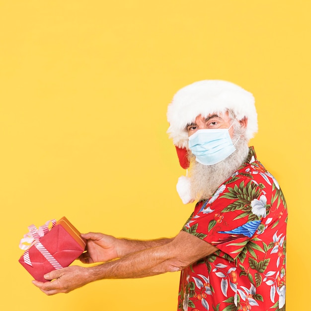 Mann mit tropischem Hemd und Weihnachtsmütze mit Kopienraum