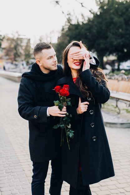 Mann mit überraschendem jungem Mädchen der Rosen