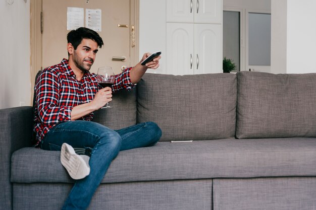 Mann mit Wein auf der Couch