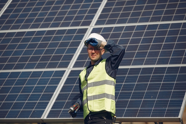 Mann mit weißem Sturzhelm nahe einem Sonnenkollektor