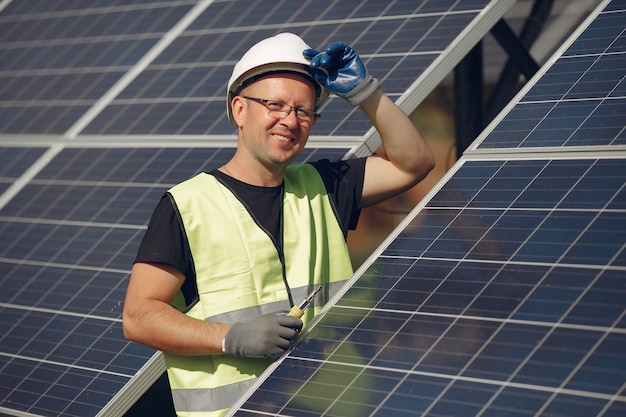 Mann mit weißem Sturzhelm nahe einem Sonnenkollektor