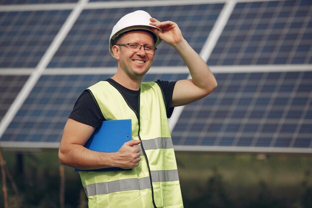 Mann mit weißem Sturzhelm nahe einem Sonnenkollektor